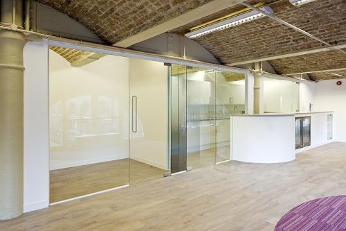 Frameless glass partition system with glass doors